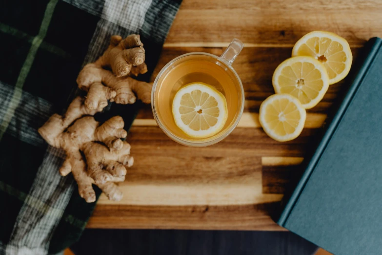 a cup of tea sitting on a wooden table with orange slices