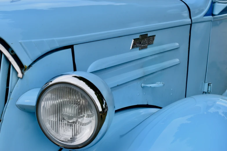 an old, blue vehicle with a light turned on