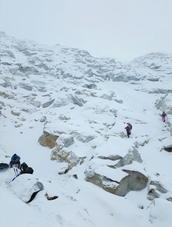 people trek in the snow on top of a mountain