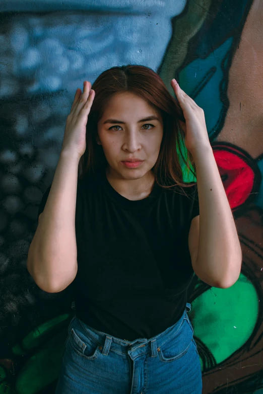 a woman poses with her hands behind her head