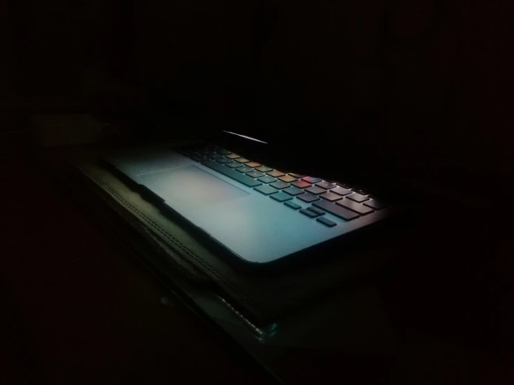 the laptop computer is shining brightly in the dark