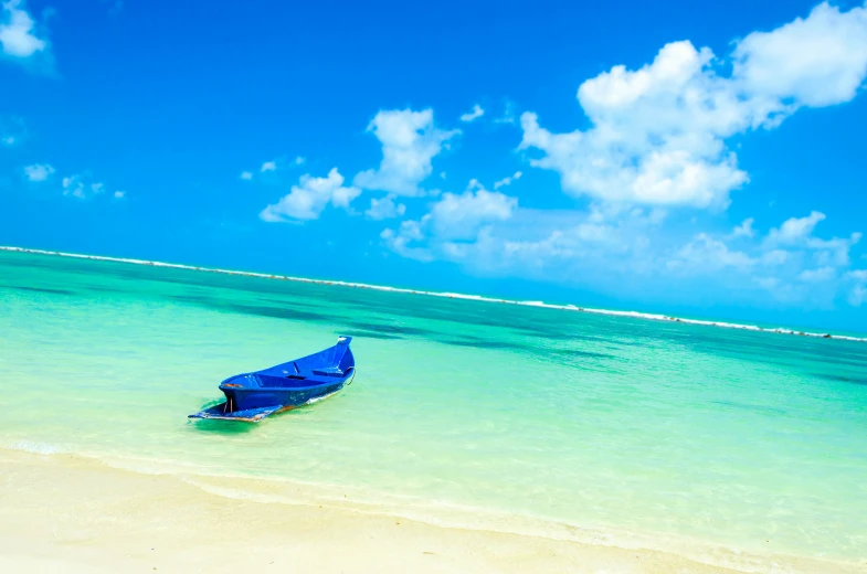 a small boat sits on the shore line in the ocean