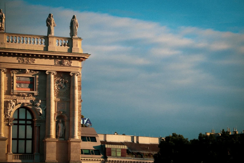 a building on the corner has statues of women perched on the roof