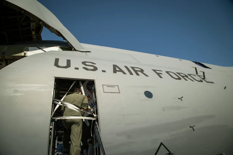 an air force plane being checked for people getting off