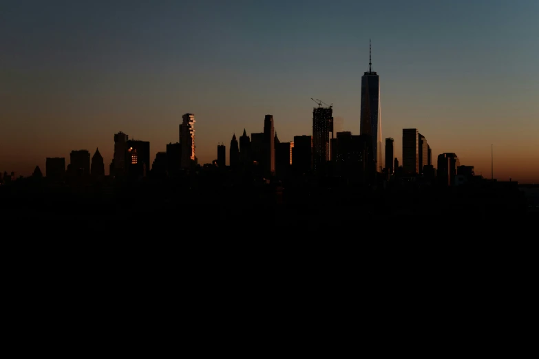 skyline in a city silhouetted against an orange and blue sky