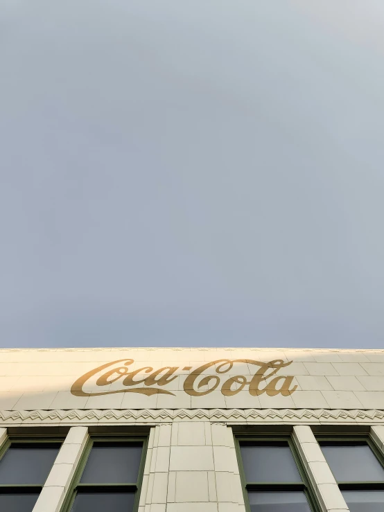 a tall building with windows next to a sign for coca - cola