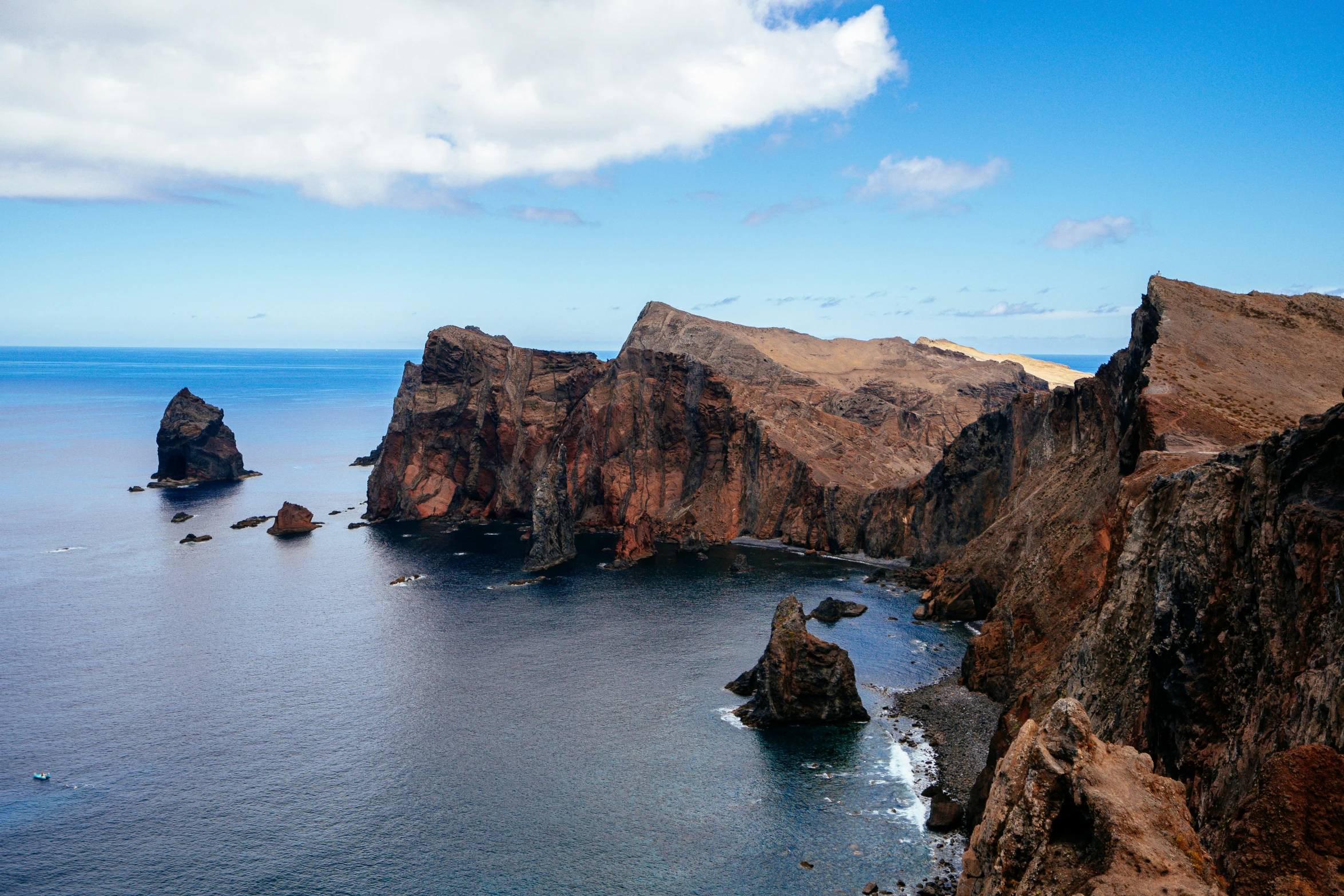 a small island off the coast of a rocky beach