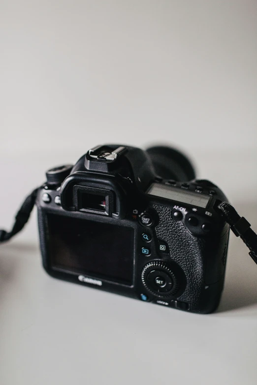 black camera with flash light on it sitting on a table