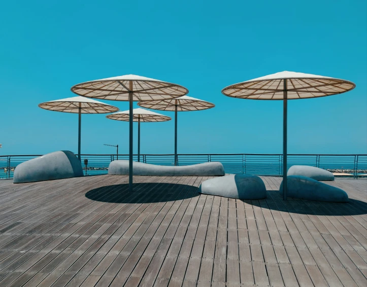 some umbrellas are on top of a building next to the ocean