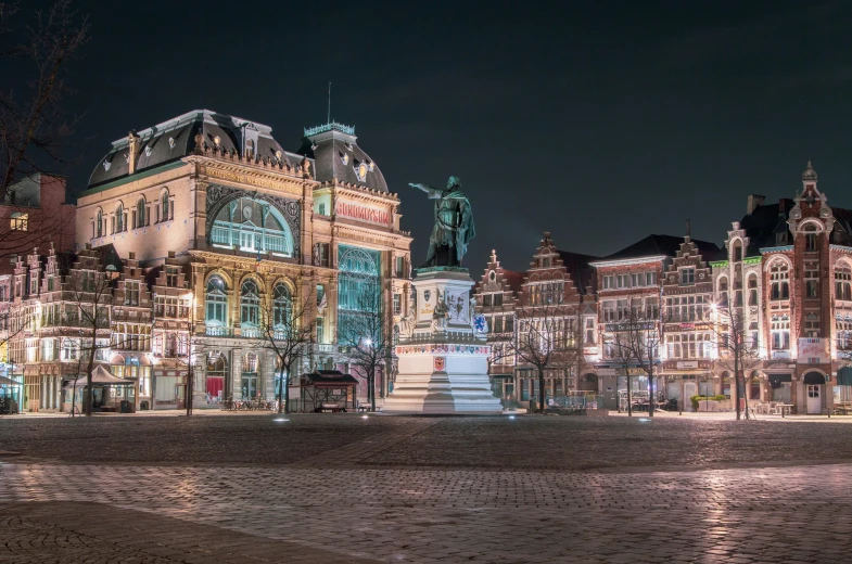 a view of a street at night in a city with lots of buildings