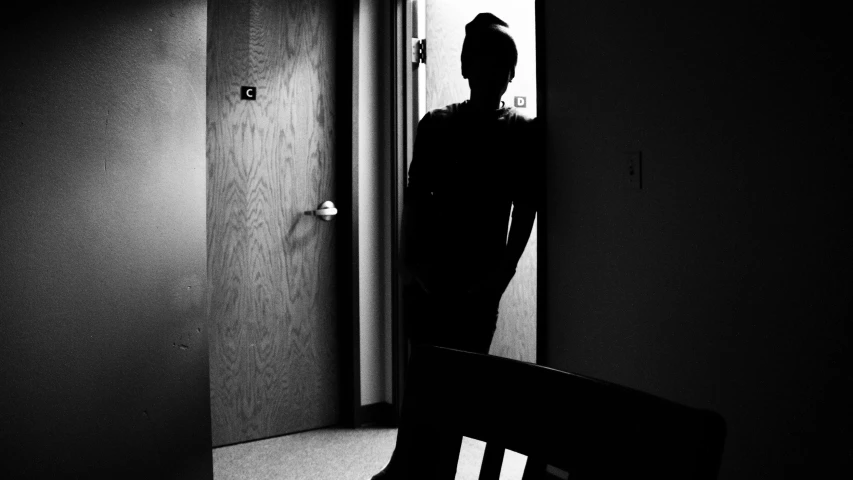 a person's shadow in a mirror near a chair