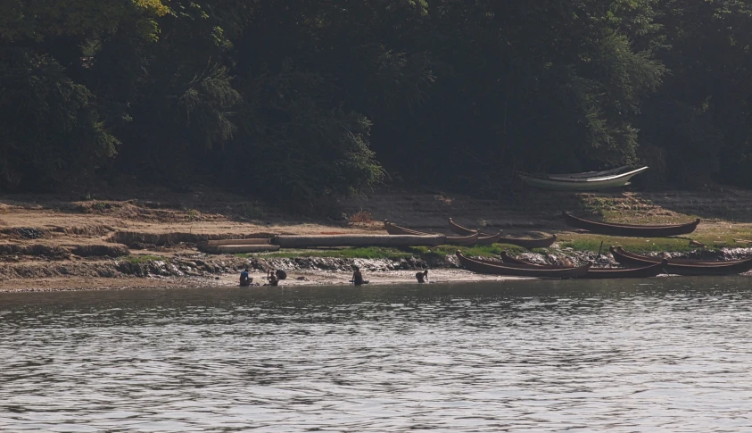 several small boats sitting on the beach near the shore