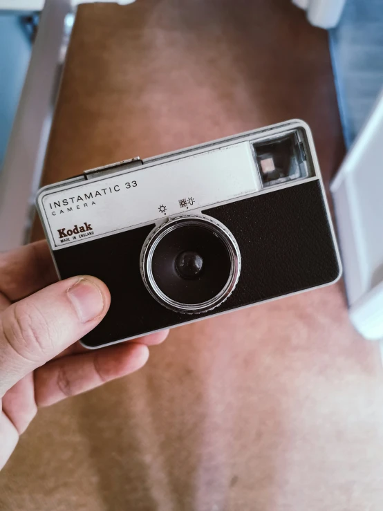 an old - style camera is held in someone's hand