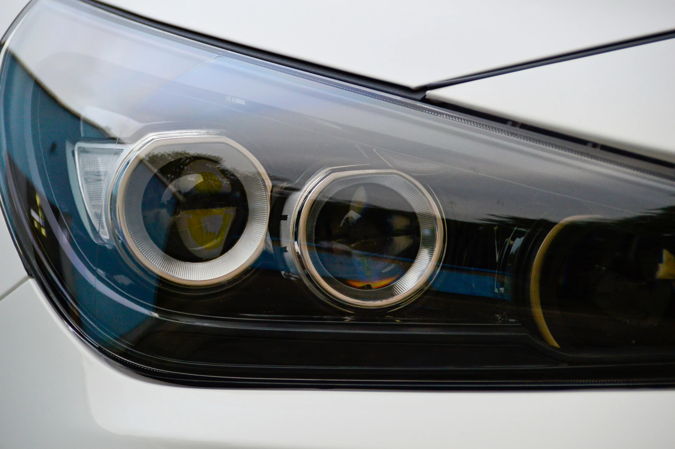 front view of a white car with circular chrome s