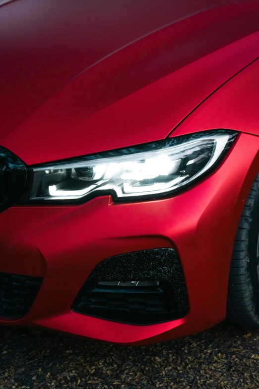 the front end of a red bmw sedan parked