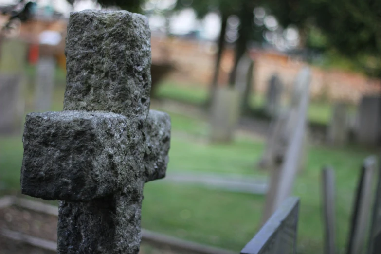 a cross made out of cement in a graveyard