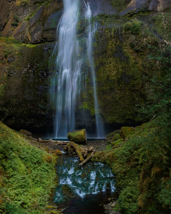 there is a waterfall flowing over rocks into the water