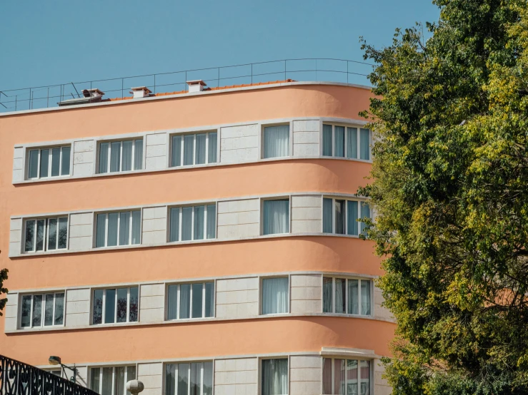 two people are standing on the roof of this pink apartment building