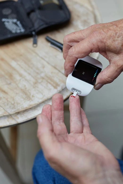 a hand is shown lighting a cigarette on a small device