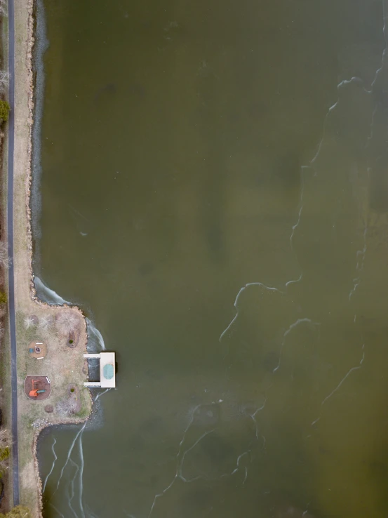 an aerial view of a small house next to the water