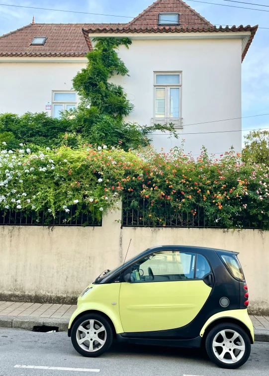 an image of a small car in front of a house