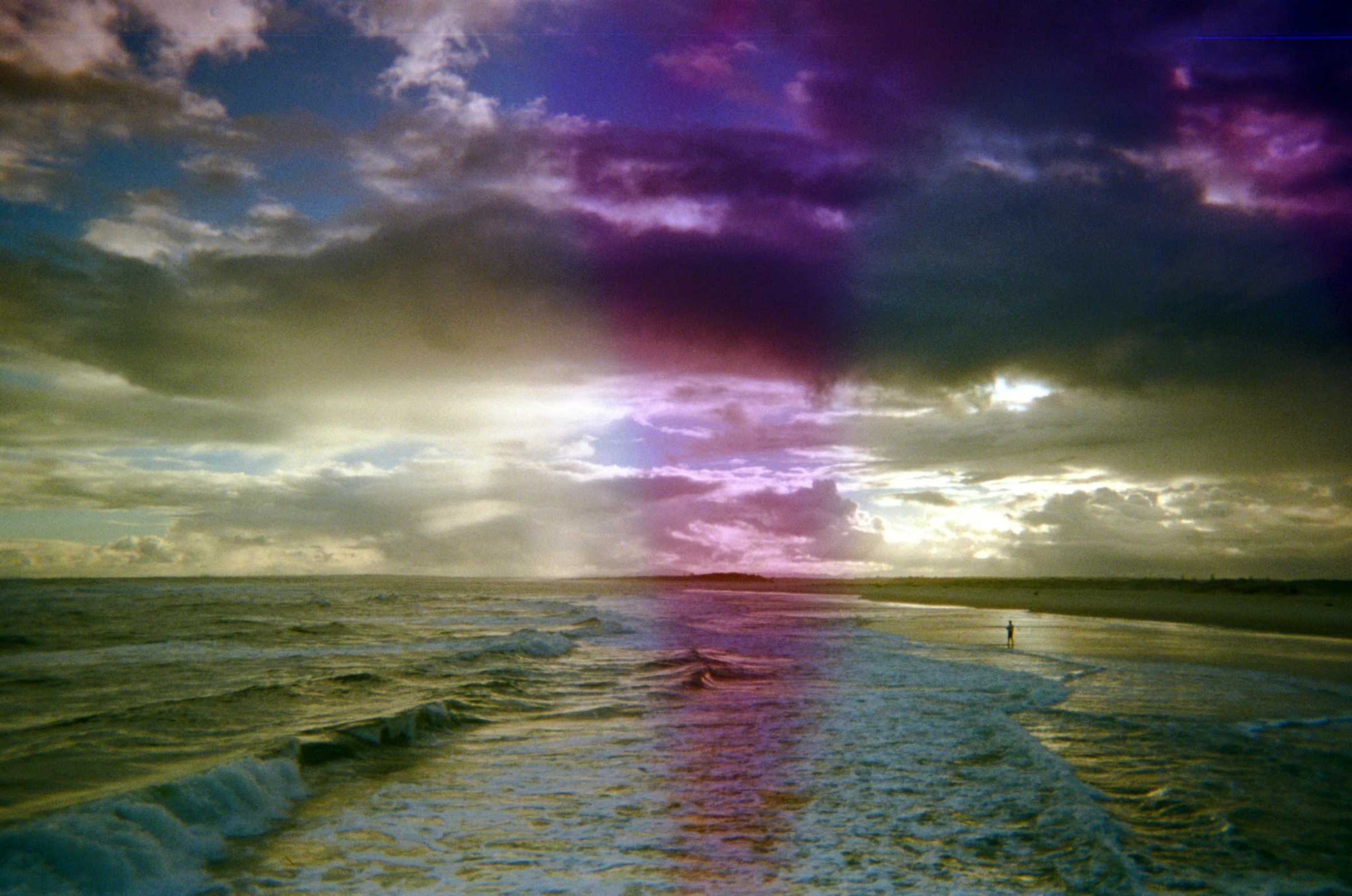 a person is walking in the ocean towards the camera