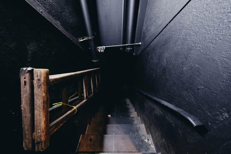 a narrow black room with an iron and wood bench