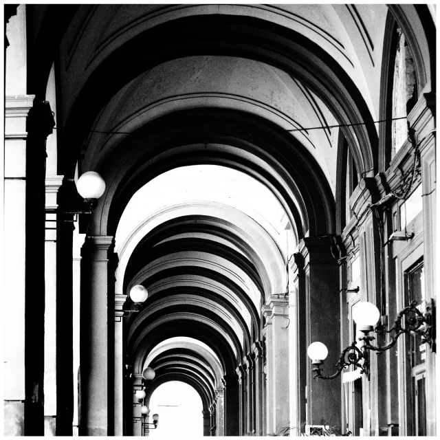 an arched building with lit up street lamps