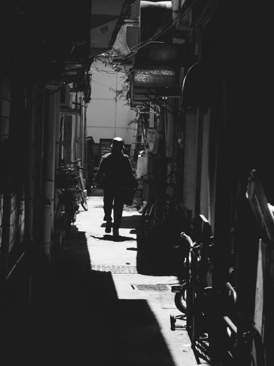 a person walking down a street between some bikes