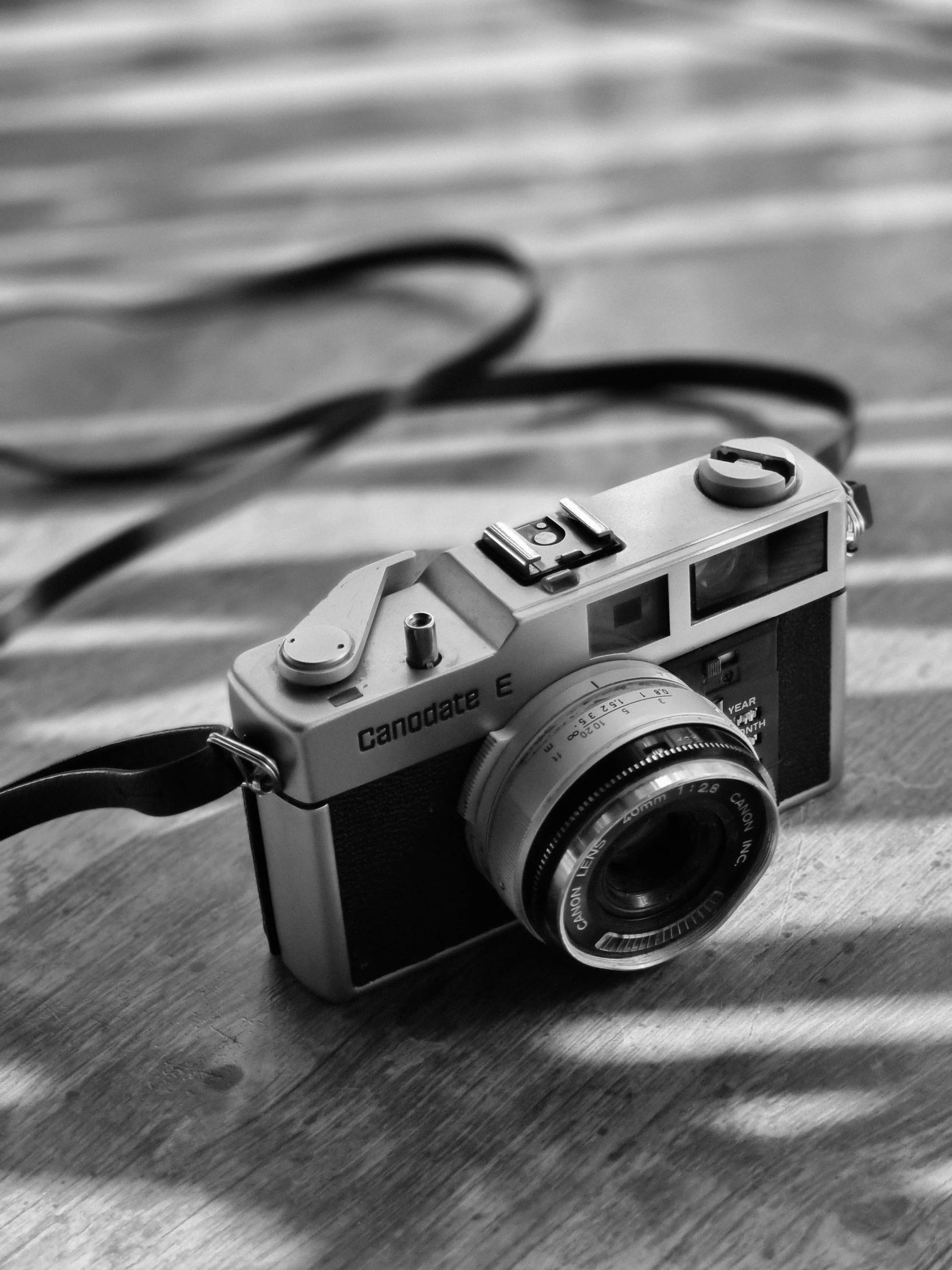 an old camera on a wooden surface and a cable