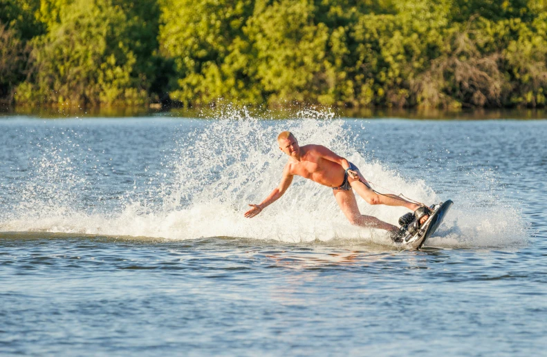 a man falling off his ski board in the water