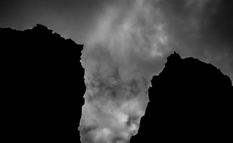 a plane flying through the air with dark clouds in the background