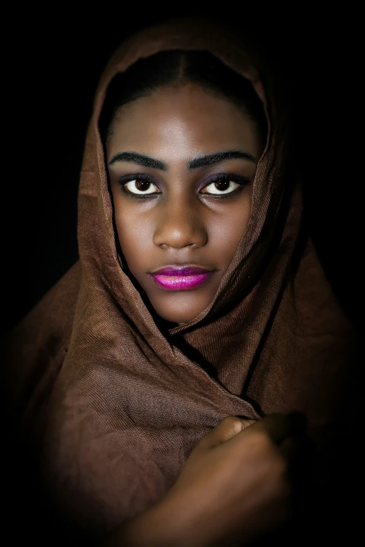 a woman in a brown veil has her eyes half covered