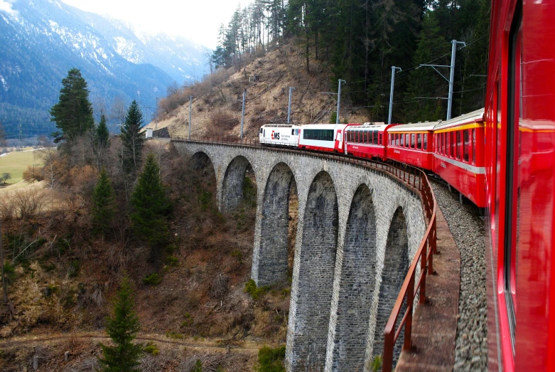 red and white train traveling over an bridge