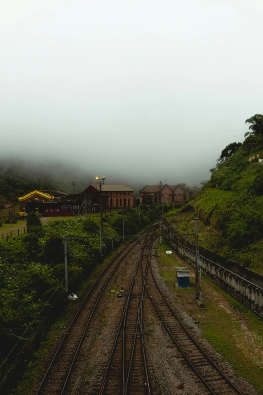 the railroad tracks go down the hill near some buildings