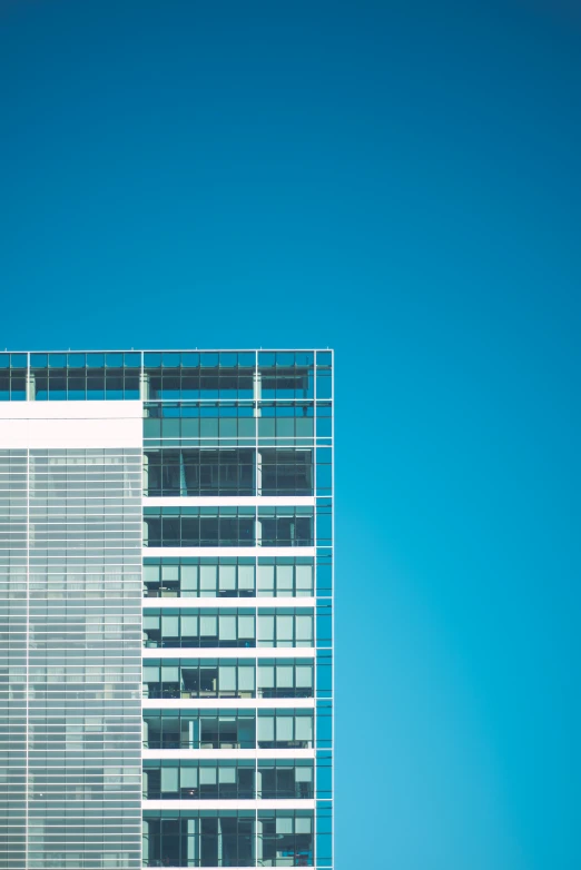 a very tall building with a few windows next to a plane