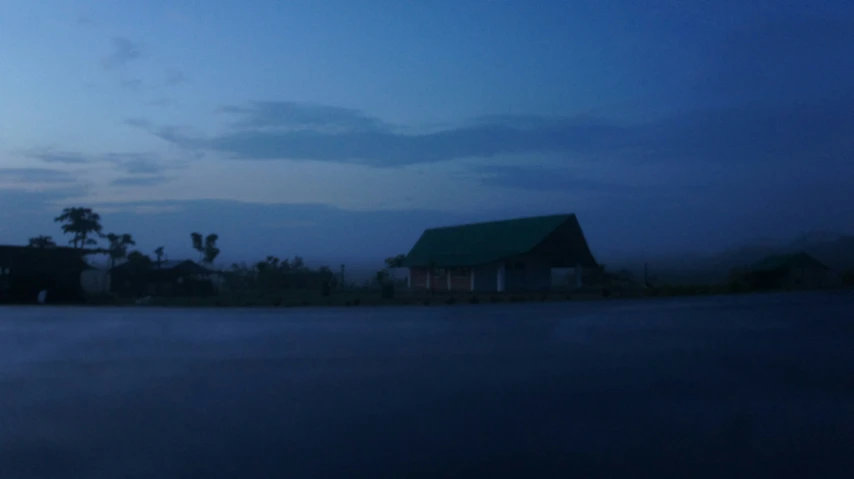 a house near the road with fog on the ground