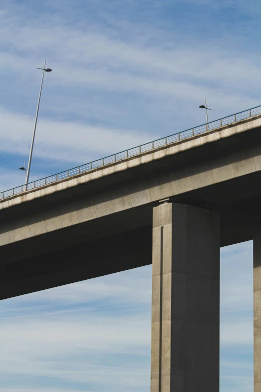 an airplane landing in front of the bridge