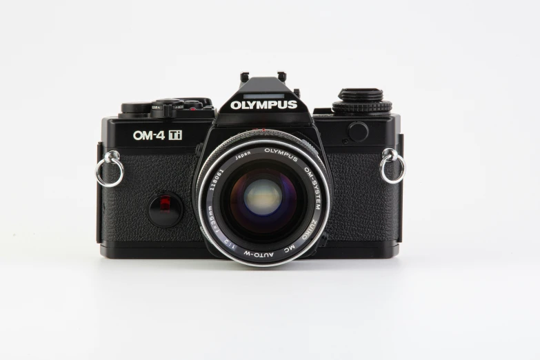 a camera sitting on a white surface with the lens out