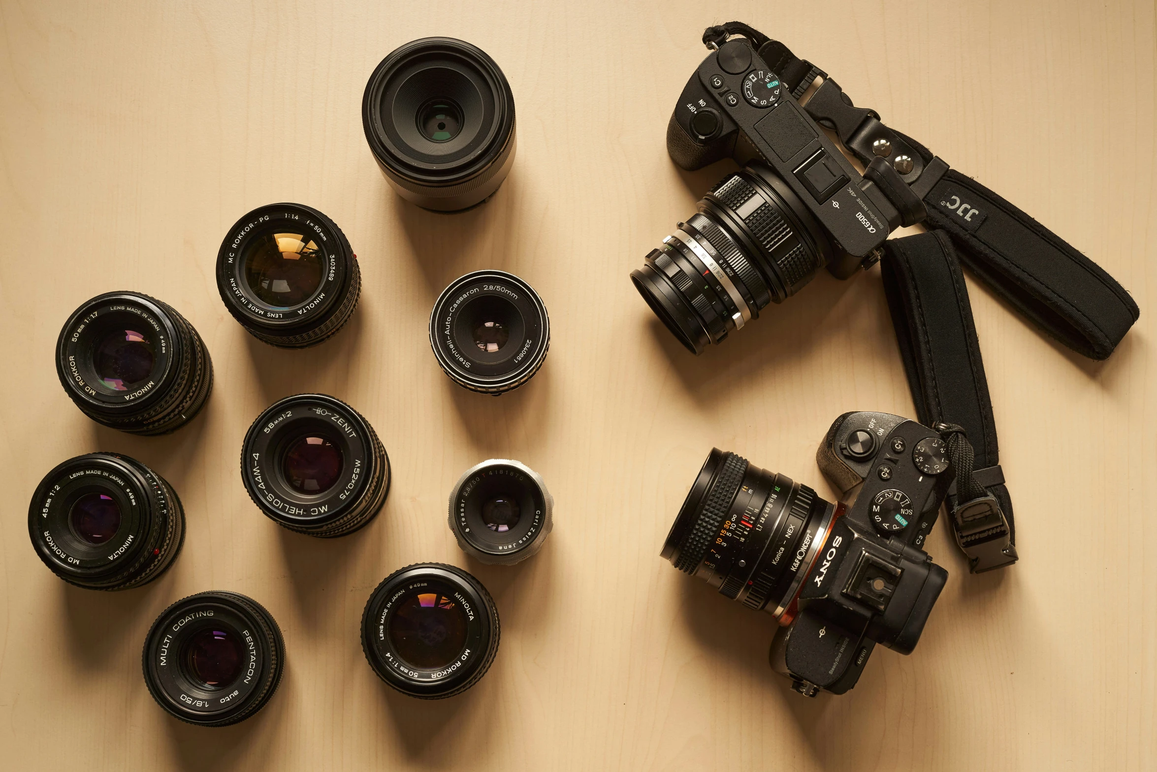 a large selection of black cameras on a table
