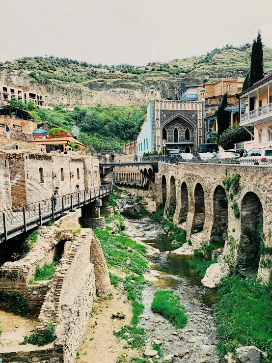 a old bridge over a small river in a town