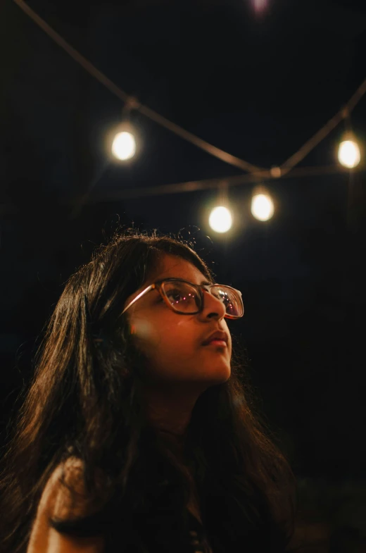 a woman is looking up at the lights on the ceiling