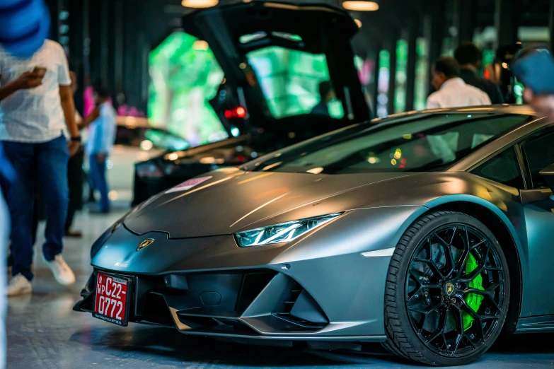 a gray lamb - cent car sits in front of people