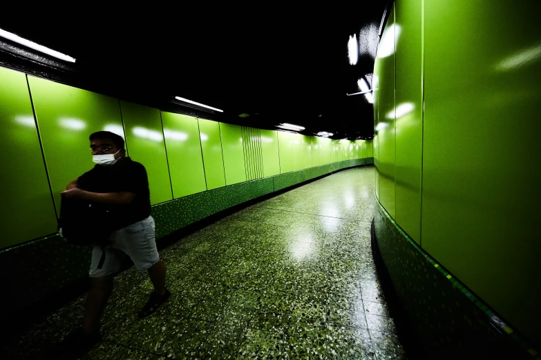 a man walking down an empty, dark corridor
