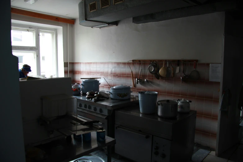 a man is in the kitchen with dishes on the stove