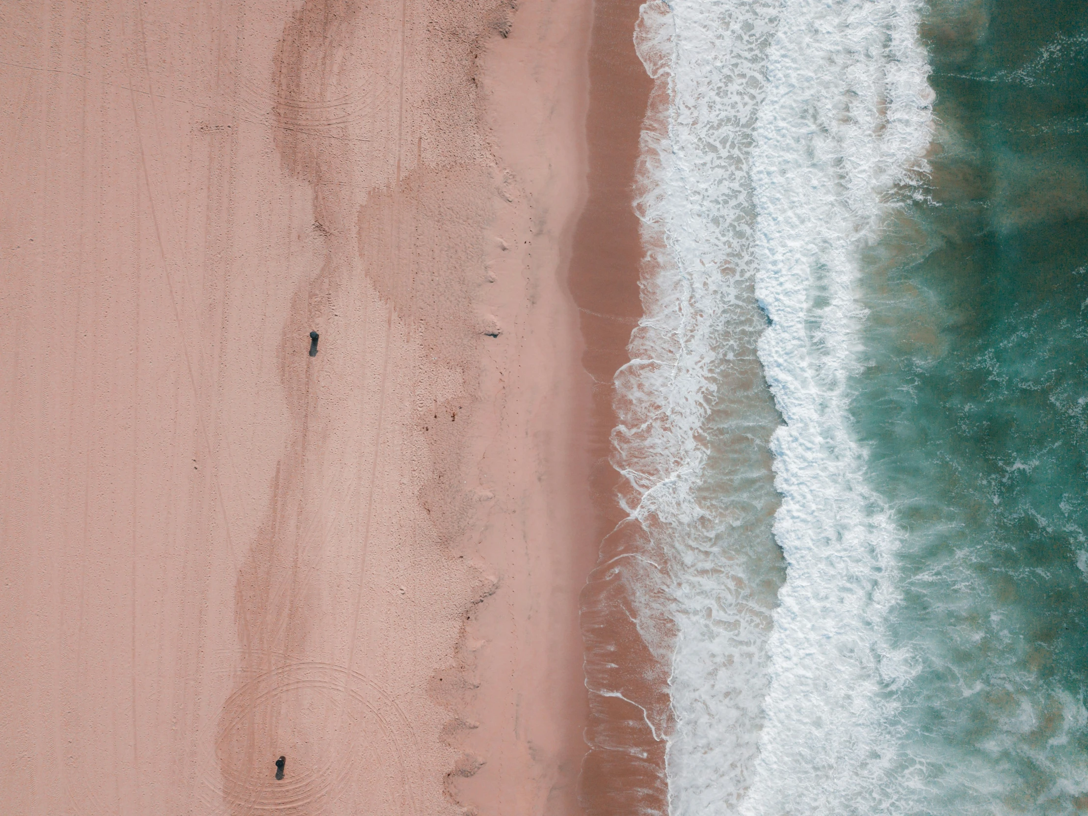 a couple of people standing on top of a beach