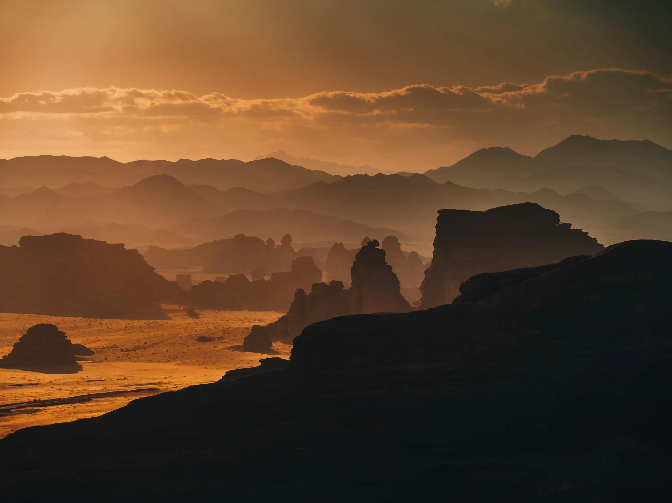 a person stands on a rocky mountain looking at the sunset