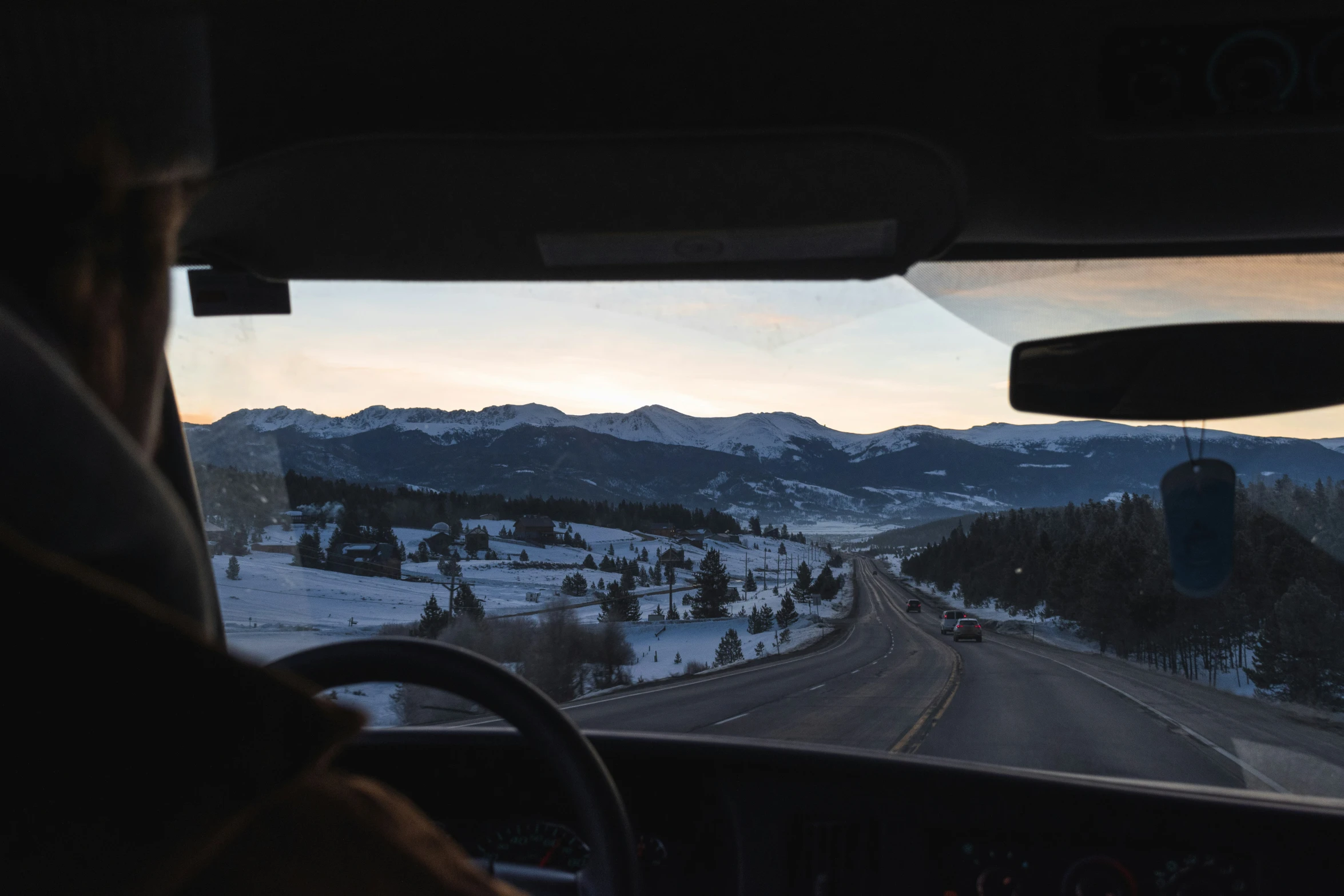 an icy mountain with trees on both sides and mountains in the background