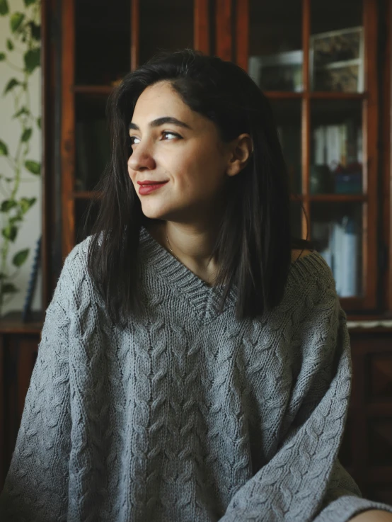 a woman in a sweater stares upward into the sky