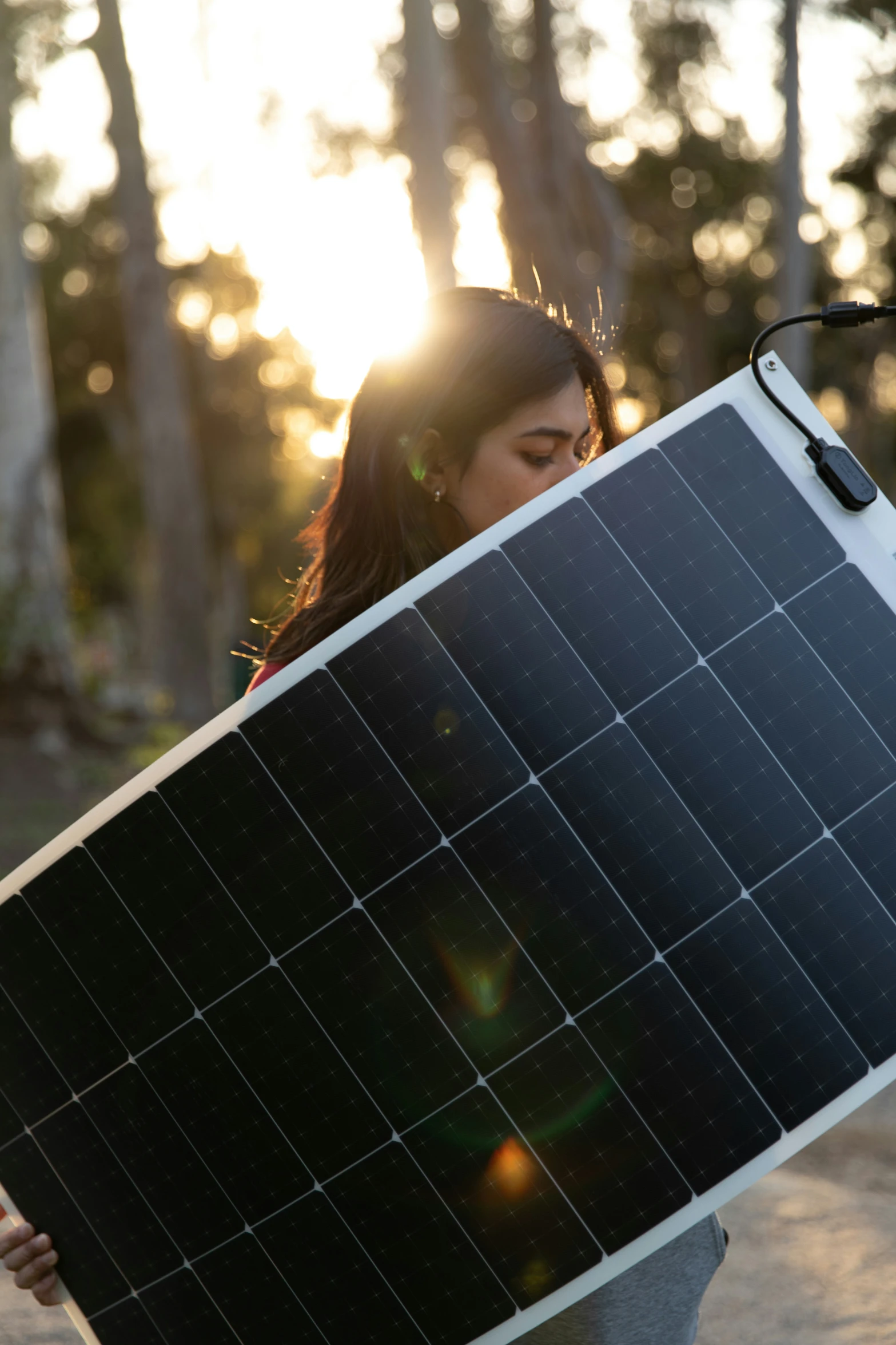 the person is holding up a solar panel